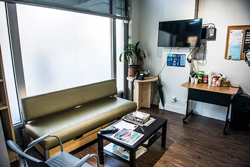 The drop-in lounge: a long couch, a coffee table with magazines, a TV and a snack table